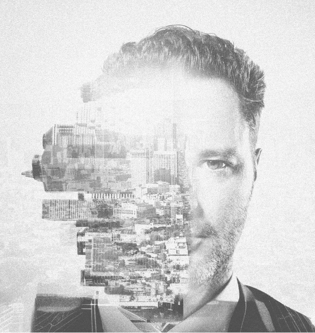 Retrato en blanco y negro de un hombre en doble exposición con el skyline de una ciudad